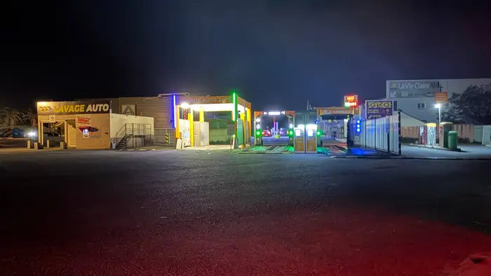 La station Dream Wash de nuit, éclairée aux néons oranges